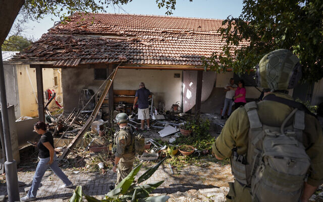 Les forces de sécurité israéliennes et les résidents examinant une maison touchée par une roquette tirée depuis le Liban, au kibboutz Saar, le 25 septembre 2024. (Crédit : Baz Ratner/AP) Les forces de sécurité israéliennes et les résidents examinant une maison touchée par une roquette tirée depuis le Liban, au kibboutz Saar, le 25 septembre 2024. (Crédit : Baz Ratner/AP)