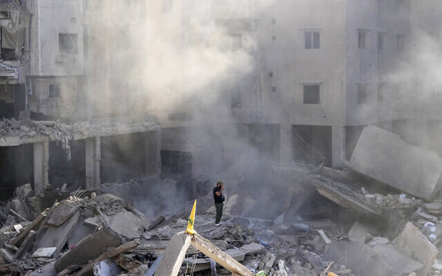 Un homme au milieu des décombres d'immeubles près du site où chef du Hezbollah Hassan Nasrallah a été éliminé, dans la banlieue sud de Beyrouth, le 29 septembre 2024. (Crédit : Hassan Ammar/AP)