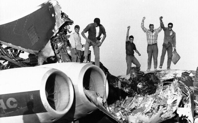 Des terroristes palestiniens célébrant l'explosion d'un avion de ligne Boac détourné vers Dawson's Field, une piste d'atterrissage située dans le désert au nord d'Amman, en Jordanie, le 14 septembre 1970. (Crédit : AP Photo)