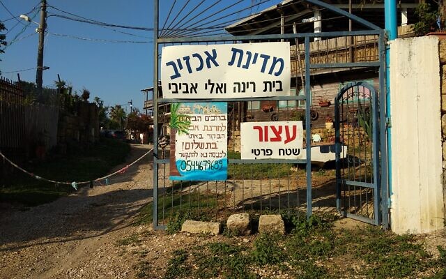 Entrée d'Akhzivland, la micronation fondée en 1971 par Eli Avivi au nord de Nahariya, le 14 avril 2018. Le panneau en hébreu indique : « Bienvenue à Akhzivland. La visite du site est payante. Pour entrer, veuillez téléphoner » (Crédit : David Shay / CC BY-SA 4.0)