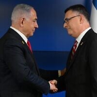 Le Premier ministre Benjamin Netanyahu (à gauche) serrant la main du leader de Tikva Hadasha, Gideon Saar, après que ce dernier a annoncé sa rentrée au gouvernement, le 29 septembre 2024. (Crédit : Chaïm Tzach/GPO)
