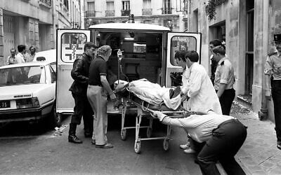 Des infirmières et des secouristes transportant un blessé à l'arrière d'une ambulance après l'attentat terroriste du 9 août 1982 contre le restaurant juif Jo Goldenberg, situé rue des Rosiers à Paris, en France. Cet attentat antisémite a fait six morts et de nombreux blessés. (Crédit : Aulnay/AP)
