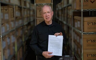 Le ministre de la Défense Yoav Gallant tenant un document écrit par l'ancien commandant de la Brigade Khan Younès du Hamas, Rafaa Salameh, sur une base de renseignement de l’armée israélienne, dans le centre d'Israël, le 11 septembre 2024. (Crédit : Ariel Hermoni/Ministère de la Défense)