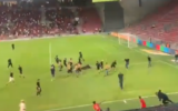 Des supporters de Hapoel Beer Sheva et de Bnei Sakhnin se battant sur le terrain de football après que les supporters de cette dernière équipe ont tourné le dos pendant l'hymne national, au Turner Stadium, à Beer Sheva, le 1er septembre 2024. (Crédit : Capture d’écran X ; utilisée conformément à l'article 27a de la loi sur le droit d'auteur)