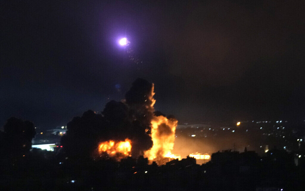 Un homme court se mettre à l'abri alors que la fumée s'élève en arrière-plan suite à une frappe aérienne israélienne sur une cible du Hezbollah à Dahiyeh, Beyrouth, Liban, le 4 octobre 2024. (Crédit : Hassan Ammar/AP)
