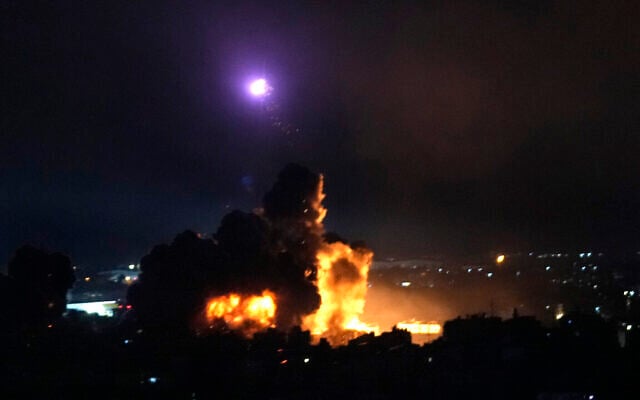 Un homme court se mettre à l'abri alors que la fumée s'élève en arrière-plan suite à une frappe aérienne israélienne sur une cible du Hezbollah à Dahiyeh, Beyrouth, Liban, le 4 octobre 2024. (Crédit : Hassan Ammar/AP)