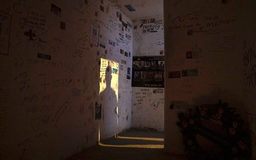 L'ombre d'un homme projetée sur le mur alors qu'il entre dans l'abri anti-bombe en bord de route où Ziv Abud a survécu, protégée par les piles de corps empilés sur elle, lors de l'attaque du Hamas le 7 octobre 2023, près du kibboutz Reïm, vue le 26 septembre 2024. (Crédit : Leo Correa/AP) L'ombre d'un homme projetée sur le mur alors qu'il entre dans l'abri anti-bombe en bord de route où Ziv Abud a survécu, protégée par les piles de corps empilés sur elle, lors de l'attaque du Hamas le 7 octobre 2023, près du kibboutz Reïm, vue le 26 septembre 2024. (Crédit : Leo Correa/AP)