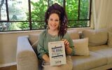 Hadassah Ben-Ari chez elle à Pardes Hannah avec une copie de son livre, « Les héros du 7 octobre », le 30 septembre 2024. (Crédit : Gavriel Fiske/Times of Israel)