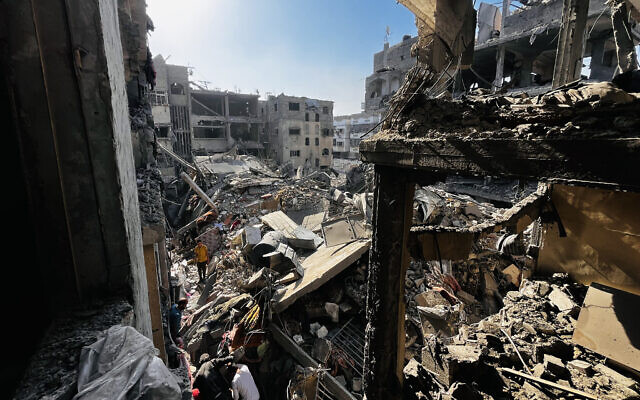 Des Palestiniens fouillant les décombres d'un bâtiment après une frappe israélienne, à Beit Lahiya, dans le nord de la bande de Gaza, le 29 octobre 2024. (Crédit : AFP)