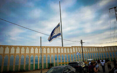 Le drapeau israélien à Netiv Haasara est mis en berne pour commémorer le premier anniversaire du massacre du 7 octobre, le 6 octobre 2024. (Crédit : Shalom Yerushalmi / Times of Israel)