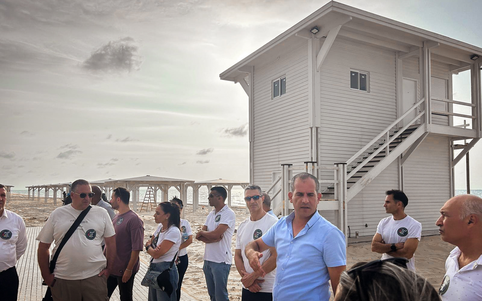 Itamar Revivo, le chef du conseil régional de la côte d'Ashkelon (vêtu d'une chemise bleu clair) à la plage de Zikim le 6 octobre 2024 (Crédit : Shalom Yerushami/Times of Israel)