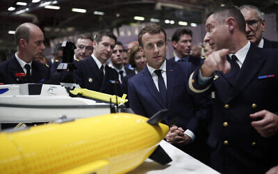 Le président français Emmanuel Macron (au centre) en visite sur un stand au salon de défense navale Euronaval, au Bourget, près de Paris, le 23 octobre 2018. (Crédit : Benoit Tessier/Pool/AFP)