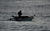 Un pêcheur pagayant sur son bateau le long du rivage d'Arugam Bay, à l'est du Sri Lanka, le 27 septembre 2020. (Crédit : Ishara S. Kodikara/AFP)