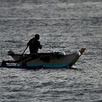 Un pêcheur pagayant sur son bateau le long du rivage d'Arugam Bay, à l'est du Sri Lanka, le 27 septembre 2020. (Crédit : Ishara S. Kodikara/AFP)