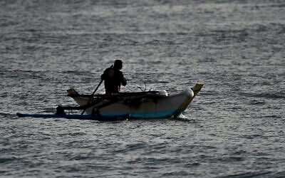 Un pêcheur pagayant sur son bateau le long du rivage d'Arugam Bay, à l'est du Sri Lanka, le 27 septembre 2020. (Crédit : Ishara S. Kodikara/AFP)