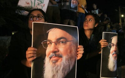 Des manifestants tenant des photos de Hassan Nasrallah, chef défunt du groupe terroriste chiite libanais du Hezbollah, lors d'une veillée de protestation dans la ville de Sidon, dans le sud du Liban, le 28 septembre 2024. (Crédit : Mahmoud Zayyat/AFP)