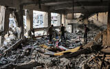 Des personnes inspectant une salle de classe détruite à la suite d'un bombardement israélien sur l'école gouvernementale palestinienne désaffectée de Muscat, dans la ville de Gaza, le 2 octobre 2024. (Crédit : Omar Al-Qattaa/AFP)