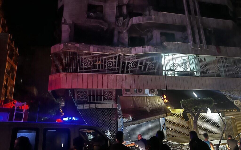 Des personnes réunies sur le site d'une frappe aérienne israélienne qui a visé un immeuble d'habitation dans le quartier de Bashura, à Beyrouth, le 3 octobre 2024. (Credit : Ibrahim Amro/AFP)