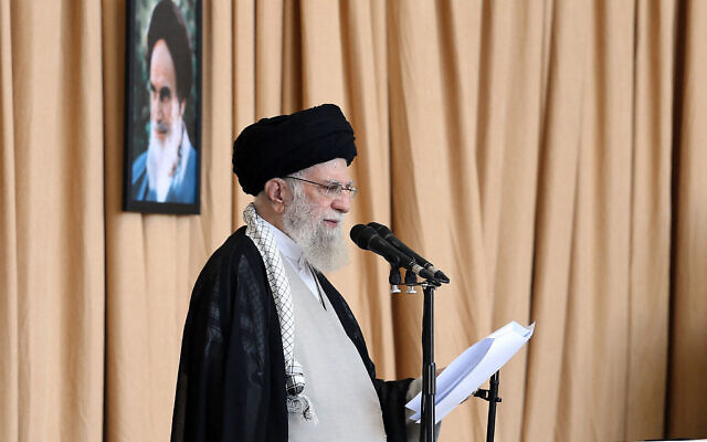 Le guide suprême iranien, l'ayatollah Ali Khamenei, tenant un fusil alors qu'il prononce un sermon lors de la cérémonie de la prière du vendredi à Téhéran, en Iran, le 4 octobre 2024. Derrière lui se trouve un portrait du fondateur de la République islamique, Ruhollah Khomeini. (Credit : Khamenei.ir/AFP) Le guide suprême iranien, l'ayatollah Ali Khamenei, tenant un fusil alors qu'il prononce un sermon lors de la cérémonie de la prière du vendredi à Téhéran, en Iran, le 4 octobre 2024. Derrière lui se trouve un portrait du fondateur de la République islamique, Ruhollah Khomeini. (Credit : Khamenei.ir/AFP)