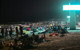 Des gens se rassemblent sur la plage d'Umm Suqeim à Dubaï dans la nuit du 5 octobre 2024.(Crédit : Giuseppe CACACE / AFP)