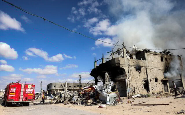 Des pompiers de la défense civile palestinienne éteigneant un incendie dans un bâtiment à Khan Younès, dans le sud de la bande de Gaza, le 7 octobre 2024. (Crédit : Bashar Taleb/AFP) Des pompiers de la défense civile palestinienne éteigneant un incendie dans un bâtiment à Khan Younès, dans le sud de la bande de Gaza, le 7 octobre 2024. (Crédit : Bashar Taleb/AFP)