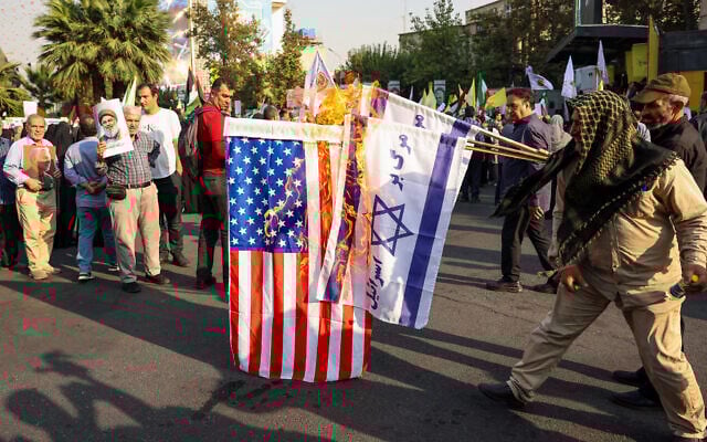 Des Iraniens brûlent des drapeaux israéliens et américains lors d'un rassemblement anti-Israël à Téhéran, le 8 octobre 2024. (Crédit : AFP) Des Iraniens brûlent des drapeaux israéliens et américains lors d'un rassemblement anti-Israël à Téhéran, le 8 octobre 2024. (Crédit : AFP)