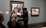 Une photo du groupe de campagne Youth Demand montrant un activiste collant une photo d'une mère et d'un enfant de Gaza sur une œuvre de Picasso intitulée « La Maternité », à la National Gallery, dans le centre de Londres, le 9 octobre 2024. (Crédit : Youth Demand/AFP)