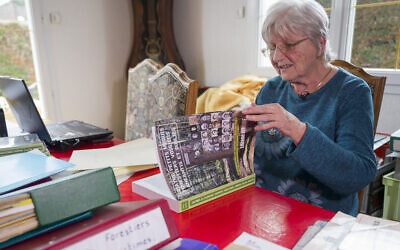 Liliane Jerome, 79 ans, ancienne enseignante, à son domicile avec son livre "Quatre petits maquis forestiers vosgiens anéantis et oublies" à Nompatelize le 30 septembre 2024. (Crédit : Jean-Christophe VERHAEGEN / AFP)