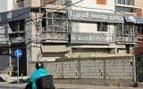 Un homme passant en mobylette devant le site d'une frappe aérienne de Tsahal qui a visé une branche d'Al-Qard Al-Hassan, une association de crédit non agréée considérée comme la banque du Hezbollah, dans la banlieue sud de Beyrouth, le 21 octobre 2024. (Crédit : AFP)