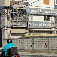 Un homme passant en mobylette devant le site d'une frappe aérienne de Tsahal qui a visé une branche d'Al-Qard Al-Hassan, une association de crédit non agréée considérée comme la banque du Hezbollah, dans la banlieue sud de Beyrouth, le 21 octobre 2024. (Crédit : AFP)