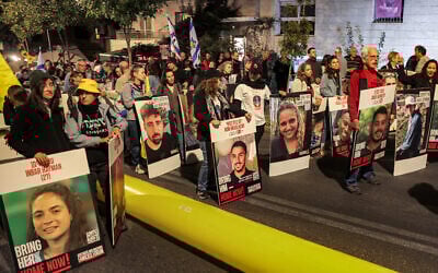Des manifestants tenant des portraits d'otages israéliens lors d'une manifestation des familles des otages détenus par le Hamas dans la bande de Gaza, devant la résidence du Premier ministre Benjamin Netanyahu, à Jérusalem, le 24 octobre 2024. (Crédit : Ahmad Gharabli/AFP)