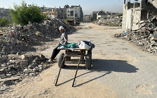 Un Palestinien blessé se repose sur un chariot transportant des corps, tués lors d'une frappe aérienne israélienne, à Beit Lahia, dans le nord de la bande de Gaza, le 27 octobre 2024, dans le cadre de la guerre en cours dans le territoire palestinien entre Israël et le Hamas. (Crédit : AFP)
