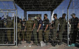 Des soldats israéliens se rassemblent face à des manifestants venus soutenir des militaires arrêtés pour des soupçons d’abus sur des détenus, à l’entrée de la base de Sde Teiman, le 29 juillet 2024. (Crédit : Tsafrir Abayov/AP)