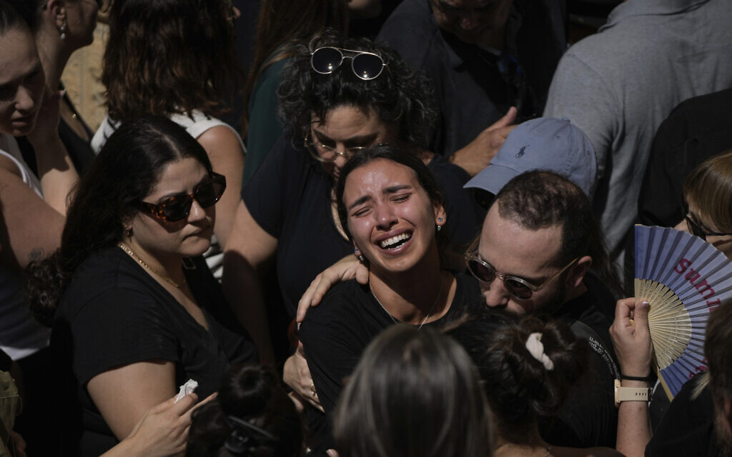 Des personnes en deuil au cours des funérailles de l'étudiant grec Ionas Karousis, tué avec six autres personnes lors d'une attaque terroriste à Jaffa, au cimetière orthodoxe grec de Jérusalem, le 5 octobre 2024. (Crédit : Mahmoud Illean/AP)