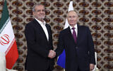 Le président russe Vladimir Poutine (à droite) et le président iranien Massoud Pezeshkian se serrant la main lors de leur rencontre en marge du Forum international "L'interconnexion des temps et des civilisations - la base de la paix et du développement", à Achgabat, au Turkménistan, le 11 octobre 2024. (Crédit : Alexander Shcherbak, Sputnik, Kremlin Pool Photo via AP)