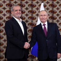 Le président russe Vladimir Poutine (à droite) et le président iranien Massoud Pezeshkian se serrant la main lors de leur rencontre en marge du Forum international "L'interconnexion des temps et des civilisations - la base de la paix et du développement", à Achgabat, au Turkménistan, le 11 octobre 2024. (Crédit : Alexander Shcherbak, Sputnik, Kremlin Pool Photo via AP)