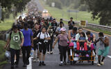 Des migrants marchant, dans l'espoir d'atteindre la frontière nord du pays et finalement les États-Unis, le long de l'autoroute Huixtla dans l'État du Chiapas, au Mexique, le 22 octobre 2024. (Crédit : Edgar H. Clemente/AP)