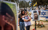 Des membres d'une famille se rendent sur le site du massacre du festival de musique Nova, six mois après l'attaque terroriste du Hamas du 7 octobre, dans la forêt de Reim, près de la frontière de Gaza, le 7 avril 2024. (Chaim Goldberg/Flash90)