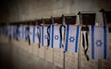 Des drapeaux d'Israël sur des tombes de soldats, au cimetière militaire du mont Herzl, à Jérusalem, avant Yom HaZikaron, le 9 mai 2024. (Crédit : Yonatan Sindel/Flash90)