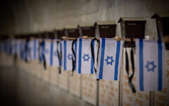 Des drapeaux d'Israël sur des tombes de soldats, au cimetière militaire du mont Herzl, à Jérusalem, avant Yom HaZikaron, le 9 mai 2024. (Crédit : Yonatan Sindel/Flash90)