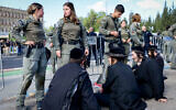 Des militants ultra-orthodoxes allongés sur le trottoir au milieu d'affrontements avec la police lors d'une manifestation contre l'enrôlement des Haredim dans l'armée israélienne, devant un bureau de recrutement, à Tel HaShomer, le 5 août 2024. (Crédit : Tomer Neuberg/Flash90)