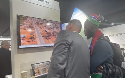 Des visiteurs découvrant les technologies de l’eau développées par BlueGreen au pavillon israélien lors de la conférence des Nations unies sur le climat, COP29, à Bakou, en Azerbaïdjan, le 14 novembre 2024. (Crédit : Sue Surkes/Times of Israel)