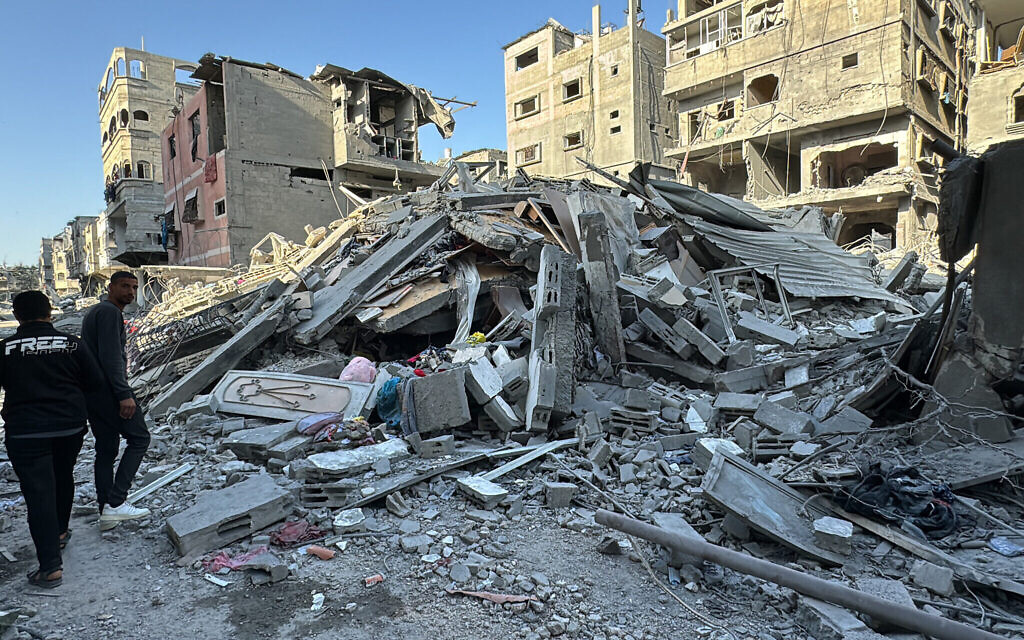 Des Palestiniens marchent à côté des débris d'un bâtiment à Beit Lahia, dans le nord de la bande de Gaza, le 21 novembre 2024. (Crédit : AFP)