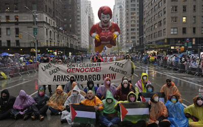 Des manifestants anti-Israël manifestant sur la Sixième Avenue pendant la parade de Thanksgiving,  à New York, le 28 novembre 2024. (Crédit :Julia Demaree Nikhinson/AP)
