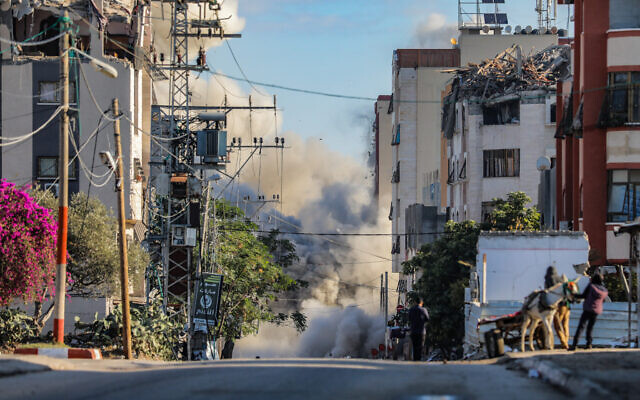Des Palestiniens courent se mettre à l'abri lors d'une frappe aérienne israélienne dans le camp de Nuseirat, dans le centre de la bande de Gaza, le 28 novembre 2024 (Crédit : Ali Hassan/Flash90)