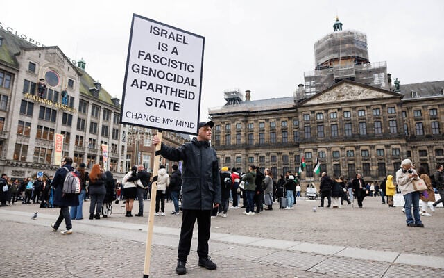 Illustration - Un manifestant tient une pancarte anti-Israël sur la place du Dam, avec le palais royal d'Amsterdam en arrière-plan, le 15 novembre 2024. (Crédit : Simon Wohlfahrt/AFP)