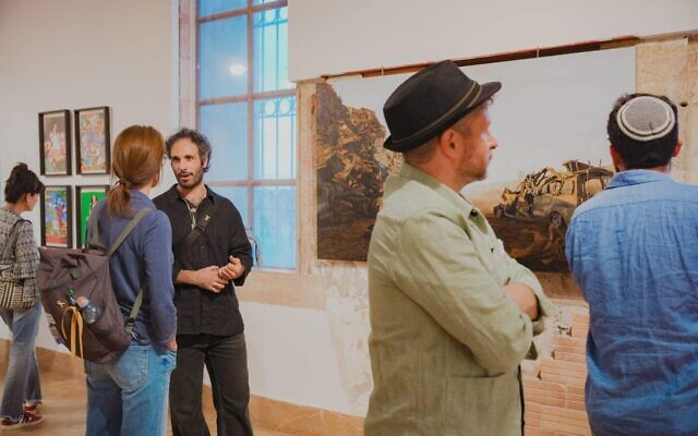Regard sur l'œuvre de l'artiste Avraham Vofsi « The Car Wall Outside Kibbutz Tkuma » lors de l'ouverture le 7 octobre 2024 de « No Words », une exposition de la Biennale de Jérusalem marquant un an depuis le pogrom brutal du Hamas, dans l'ancien bâtiment de Shaare Zedek. (Crédit : Yakov Buta)