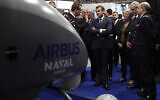 Le président français Emmanuel Macron (au centre) écoutant des explications sur un stand à Euronaval, le salon mondial de la défense navale au Bourget, près de Paris, le 23 octobre 2018. Illustration (Crédit : Benoit Tessier/Pool/AFP)