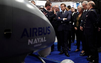 Le président français Emmanuel Macron (au centre) écoutant des explications sur un stand à Euronaval, le salon mondial de la défense navale au Bourget, près de Paris, le 23 octobre 2018. Illustration (Crédit : Benoit Tessier/Pool/AFP)