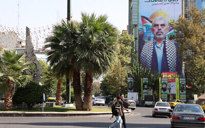 Des Iraniens passent devant un immense panneau d'affichage à l'effigie du chef du Hamas, Yahya Sinwar, sur la place de Palestine à Téhéran, le 19 octobre 2024. (Crédit : AFP)